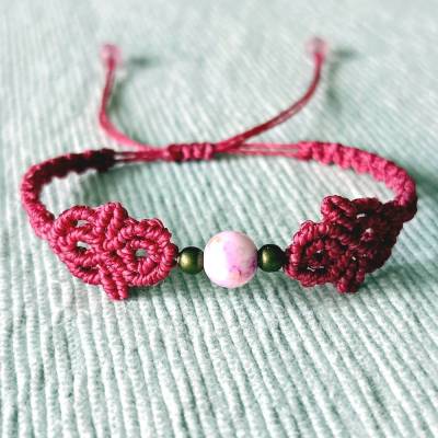 zierliches Makramee Armband in der Farbe beere mit marmorierter Acrylperle und bronzefarbenen Metallperlen