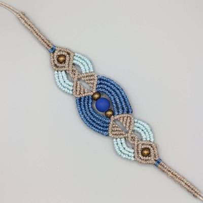 Makramee Armband in Blautönen und beige mit einer matten Acrylperle sowie bronzefarbenen Metallperlen