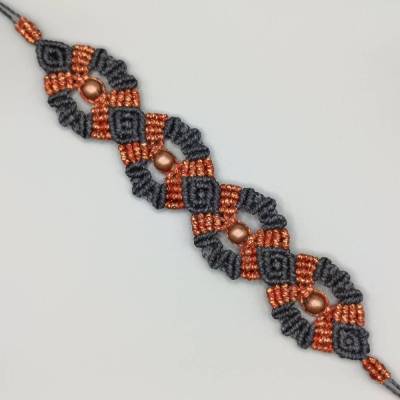 bezauberndes Makramee Armband in schwarz und metallic orange mit kupferfarbenen Metallperlen