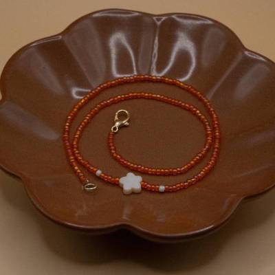 elastische Halskette aus orangenen Glasperlen mit Blumenperle in beige mit Verschluss aus Metall in gold ca. 38cm lang