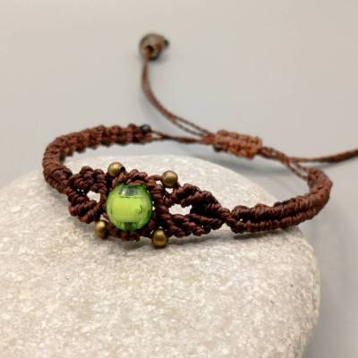 zierliches Makramee Armband in dunkelbraun mit einer grünen Acrylperle und bronzefarbenen Metallperlen