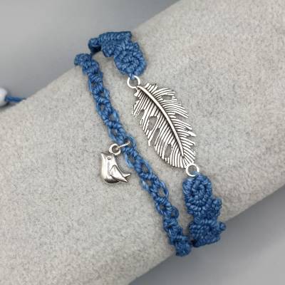 Makramee Armband 2in1 in blau mit einer silberfarbenen Feder und einem silberfarbenen Vogel