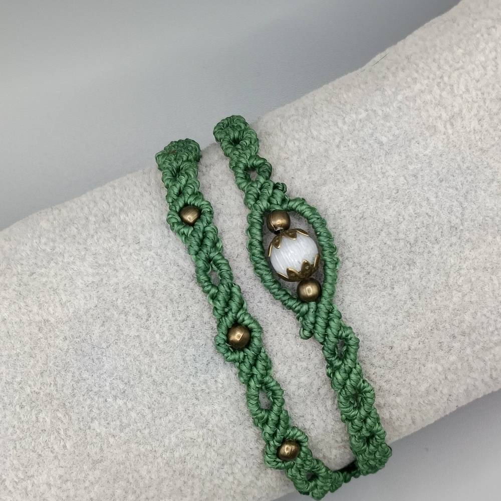 Makramee Armband 2in1 in grün mit einer weißen Glasperle und bronzefarbenen Metallperlen Bild 1