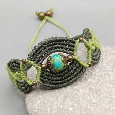 Makramee Armband in olivgrün und hellgrün mit einer marmorierten Acrylperle und bronzefarbenen Metallperlen