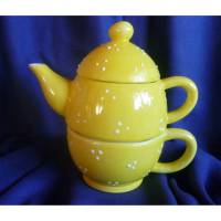 Süße gelbe Teekanne mit Tasse für 2 Tassen Tee
