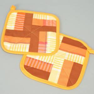Topflappen-Paar selbstgenäht Baumwolle gelb orange braun Patchwork aus Stoffresten Bild 1