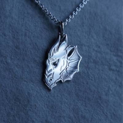 Drachenkopf mit grünem Brillanten