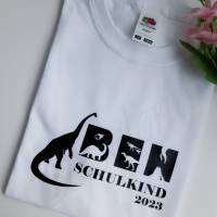 Personalisiertes T-Shirt für Jungen oder Mädchen zum Schulanfang. Schulkind 2024 mit Wunschname und Dinosaurier. Bild 2