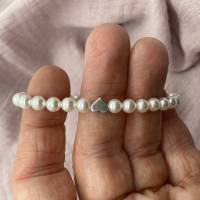 Perlenarmband mit weißen Perlen und kleinem Herz. Bild 3
