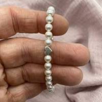 Perlenarmband mit weißen Perlen und kleinem Herz. Bild 9