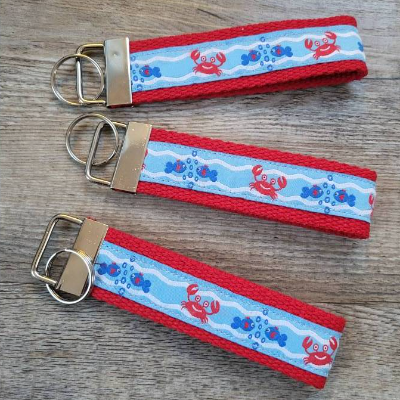 Schlüsselanhänger aus rotem Gurtband mit Webband "Krabbe und Fisch"