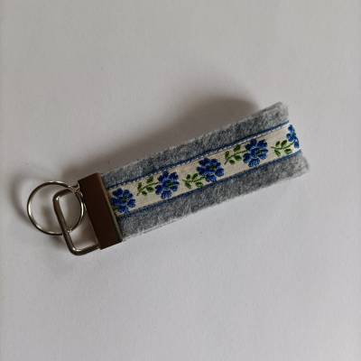 Schlüsselanhänger aus grauem Filz mit aufgenähtem Webband *Blaue Blumen*