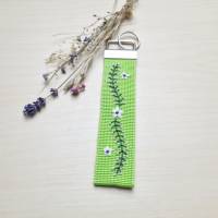 Schlüsselanhänger aus grünem Gurtband mit einer Blumenranke bestickt Bild 1