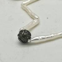 Perlenkette mit weißen schmalen Süßwasserperlen und einer schwarzen geschnitzten Tahitiperle Bild 1