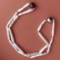 Perlenkette mit weißen schmalen Süßwasserperlen und einer schwarzen geschnitzten Tahitiperle Bild 4