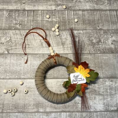 Herbstlicher Türkranz zur Dekoration im Innenbereich, bunte Blätter aus Papier schmücken den Kranz, Homedeko