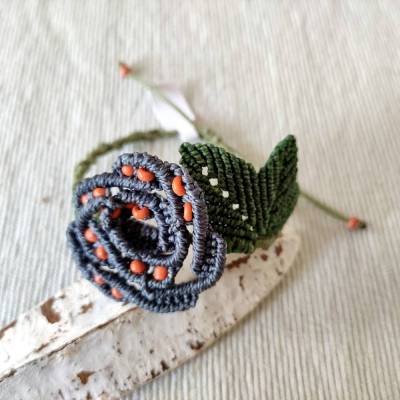 bezauberndes Makramee Armband mit einer Rosenblüte in grau und kleinen orangefarbenen Perlen