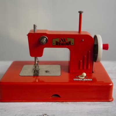 Vintage Kindernähmaschine aus den 60er Jahren.Marke "Regina"in orange.  Mit Handkurbel und Ein-Aus Schalter.  Di