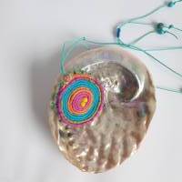Bunte runde Häkelspirale mit Perlen geschmückt als Halskette Bild 8