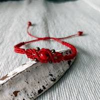 zierliches Makramee Armband in rot mit einer marmorierten Acrylperle und kleinen bronzefarbenen Metallperlen Bild 2
